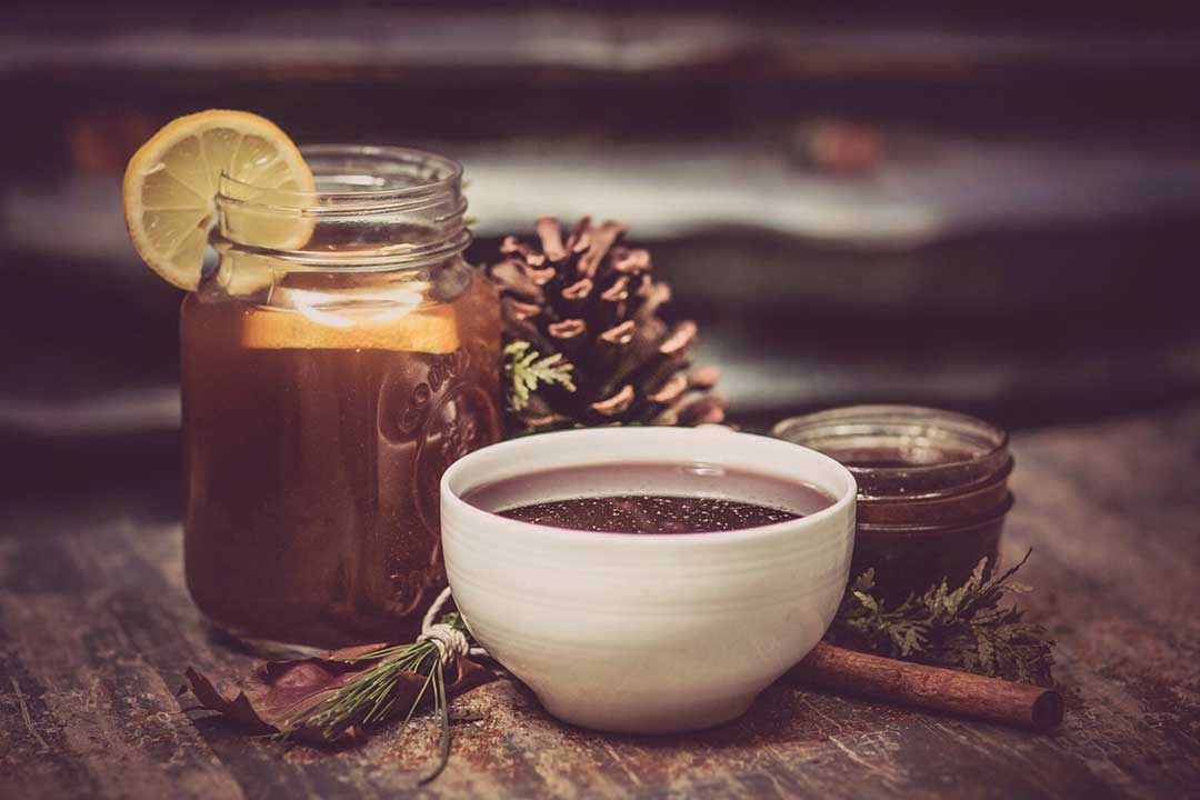 How to Cold Brew Tea—Image shows a glass of iced tea with lemon wedges and a cup of hot tea.