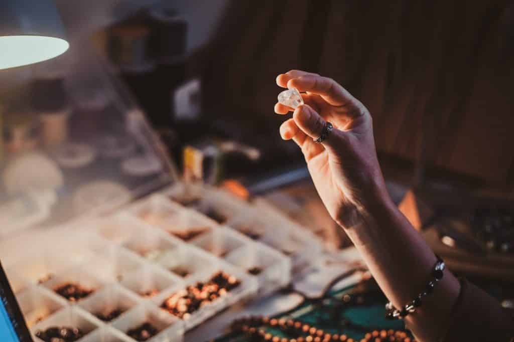 Learn how to make your own tumbled stone jewelry to wear, give as gifts, or sell at your local market days. Here are all the tools you need to get started! (Image shows a girl holding semi precious stone.)