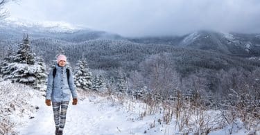 Woman Hiking High in the Mountains during Winter