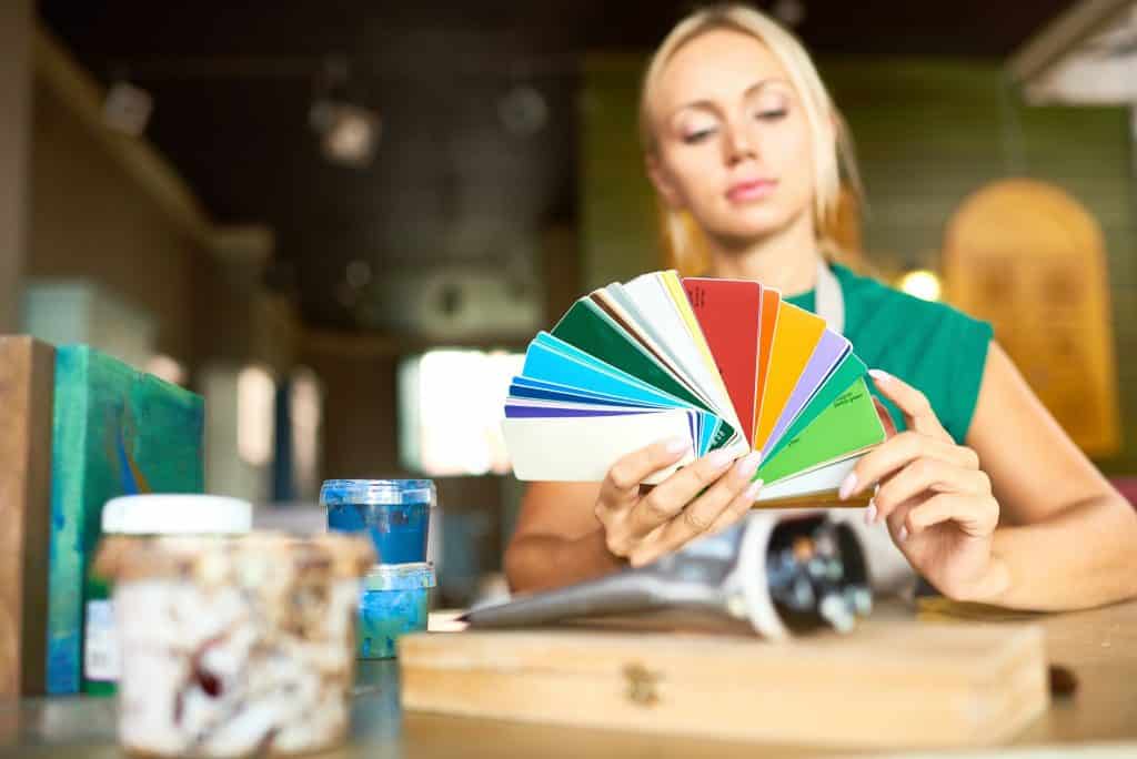 Interior design can make for a relaxing hobby and an organized space. Here's how interior design affects mental health. Image shows a designer choosing colors for interior.