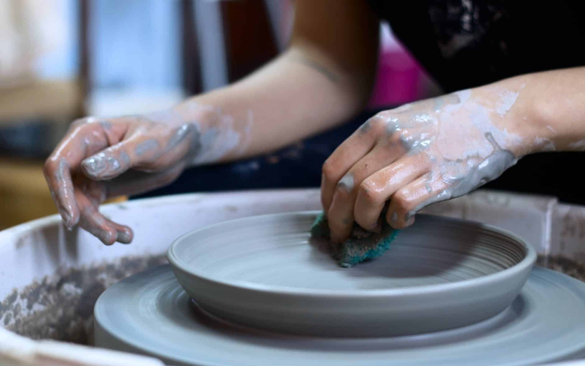 person making clay pot