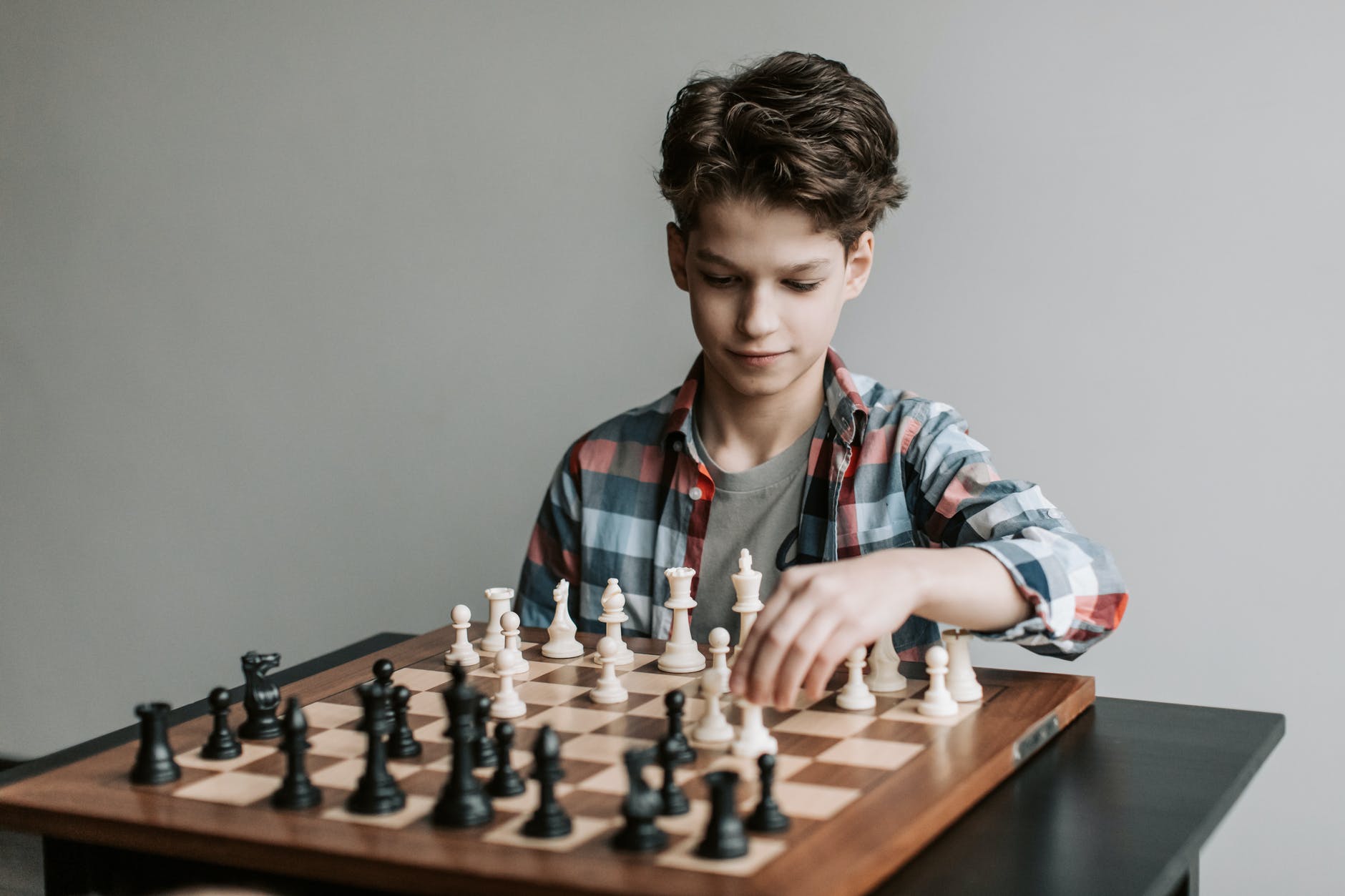 a boy making a move in a game of chess