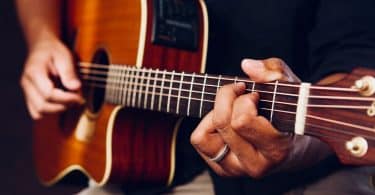 photo of person playing acoustic guitar