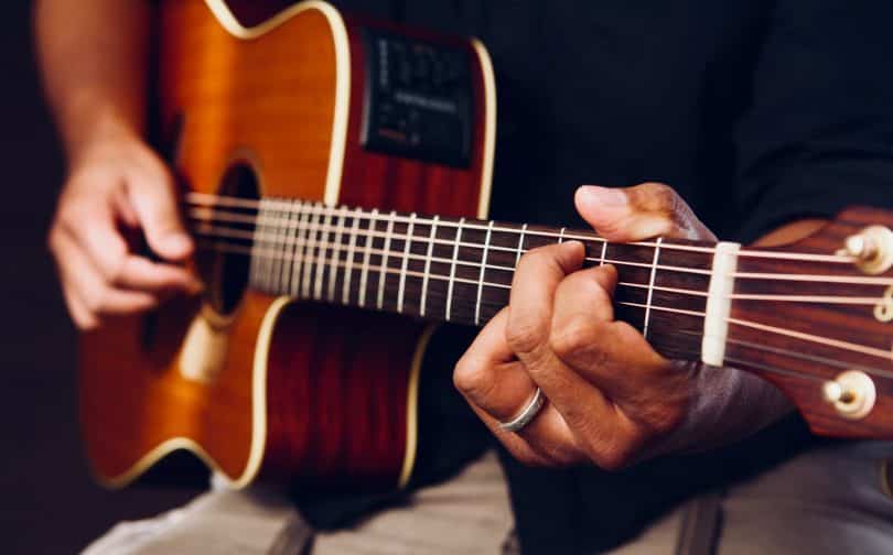 photo of person playing acoustic guitar