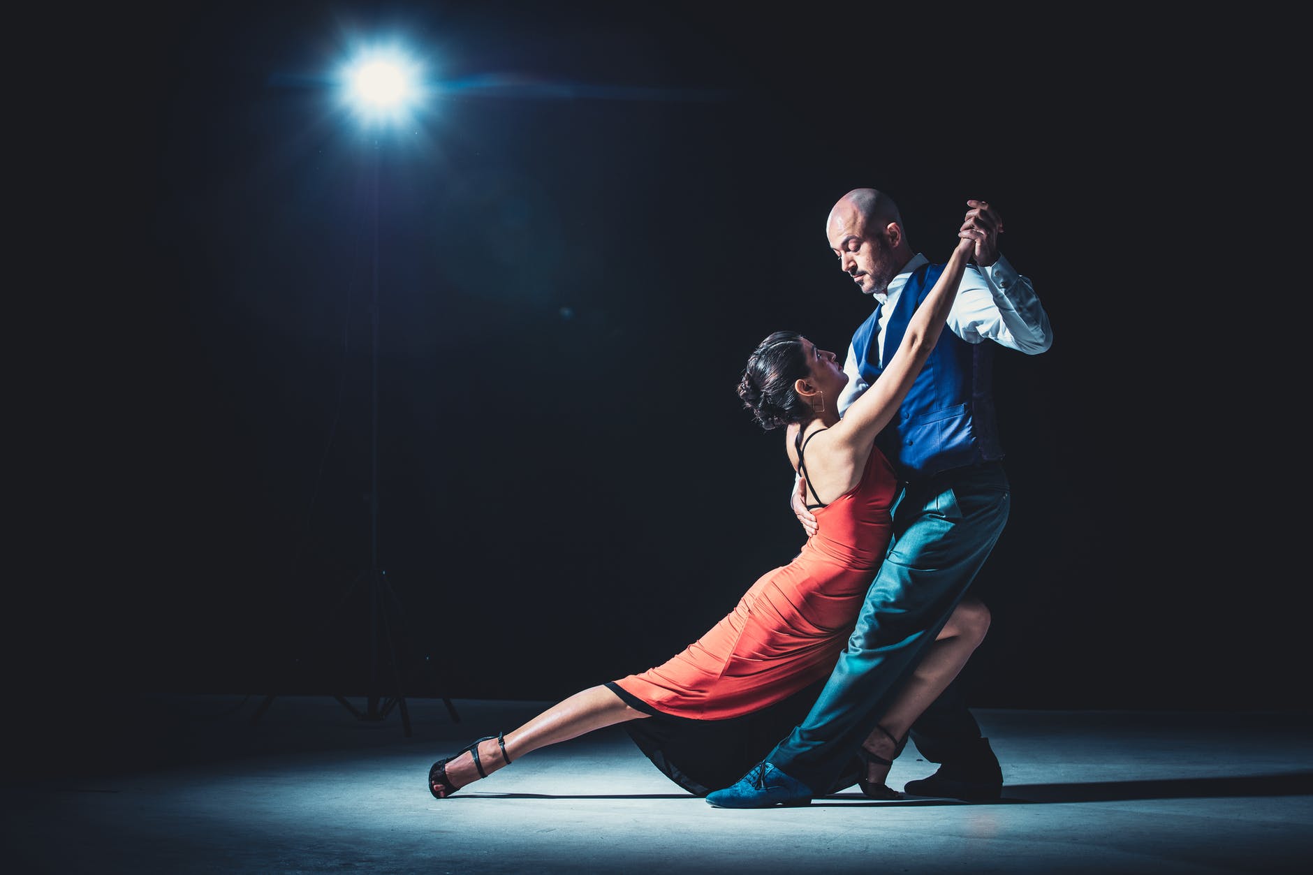 woman and man dancing under light