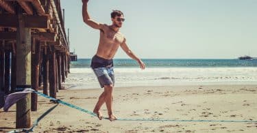 man standing on rope near beach