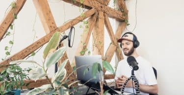 a man in white shirt doing audio podcast