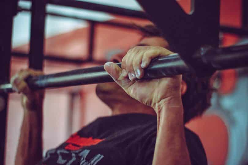 man in black crew neck shirt doing pull ups