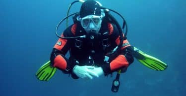 human in black orange swimming suit in blue body of water