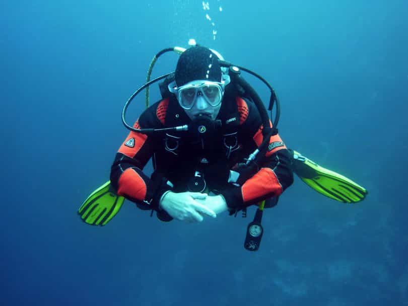 human in black orange swimming suit in blue body of water