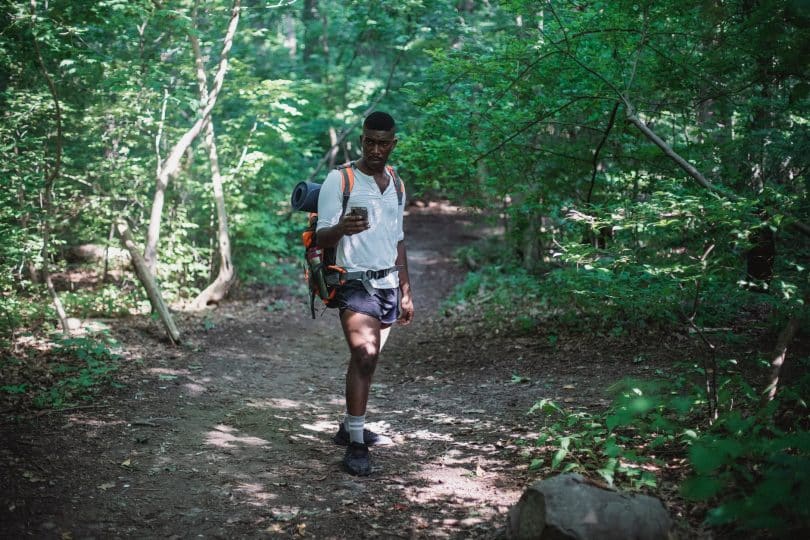 african american man with backpack in forest