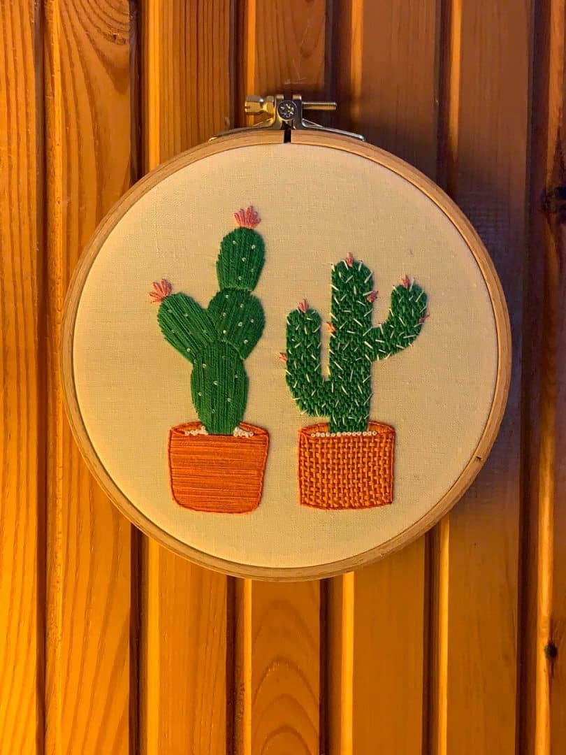 hand embroidered cactus design on wooden wall