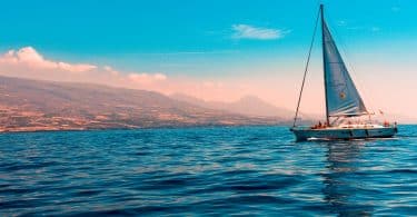 sailboat sailing on water near island