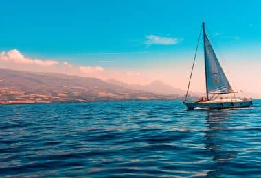 sailboat sailing on water near island