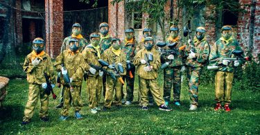 people in a military uniform holding paintball guns