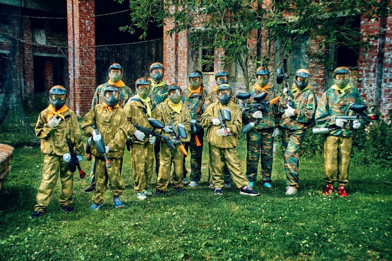 people in a military uniform holding paintball guns