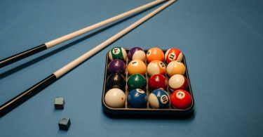 billiard balls and cue sticks on the billiard table