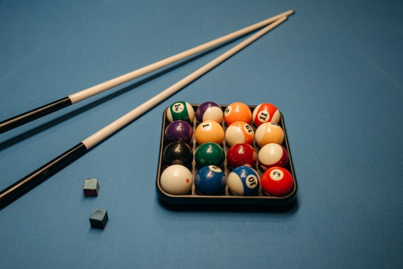 billiard balls and cue sticks on the billiard table